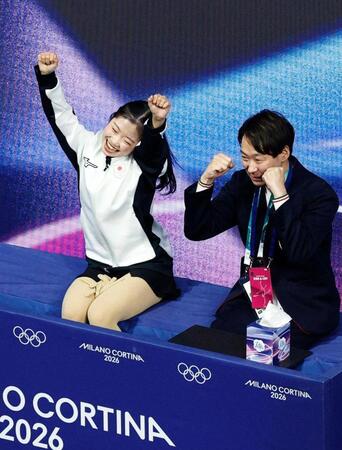 女子ＳＰの得点を確認し、喜ぶ中井亜美。右は中庭健介コーチ（共同）