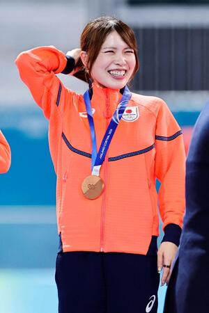 女子団体追い抜きで銅メダルを獲得し、表彰台で笑顔の佐藤綾乃＝ミラノ（共同）