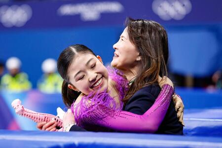 女子ＳＰの演技を終え、浜田美栄コーチ（右）と抱き合う千葉百音＝ミラノ（共同）