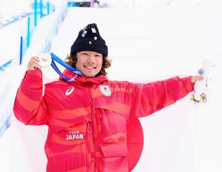 　男子スロープスタイルで獲得した銀メダルを掲げる長谷川帝勝＝リビーニョ（共同）