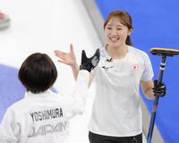 笑顔で吉村紗也香（左）とタッチする小林未奈＝コルティナ・カーリング・オリンピック・スタジアム（撮影・吉澤敬太）