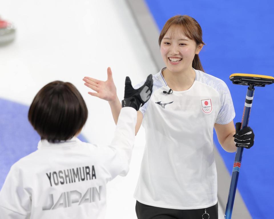 笑顔で吉村紗也香（左）とタッチする小林未奈＝コルティナ・カーリング・オリンピック・スタジアム（撮影・吉澤敬太）