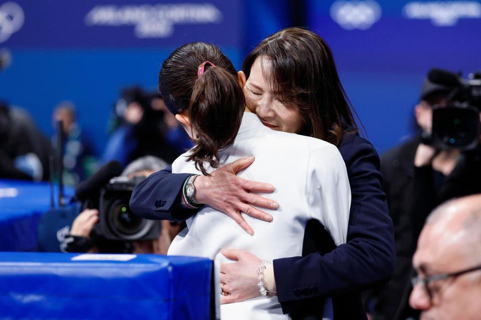 女子ＳＰの演技を終えた千葉百音（手前）を抱きしめる浜田美栄コーチ＝ミラノ（共同）