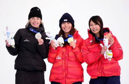ミラノ・コルティナ冬季五輪のスノーボード女子スロープスタイルで金メダルを獲得し、笑顔を見せる深田茉莉（中央）。右は銅メダルの村瀬心椛＝18日、イタリア・リビーニョ（共同）