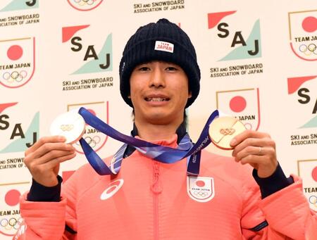 銀（左）と銅（右）のメダルを手に笑顔を見せる堀島行真＝羽田空港（撮影・佐藤厚）