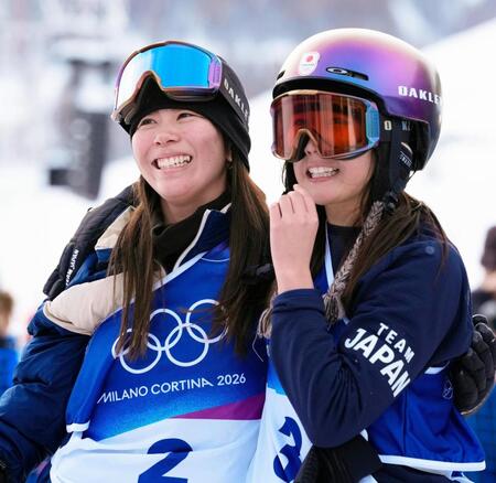 スノーボード女子スロープスタイル決勝の３回目を終え、健闘をたたえ合う深田茉莉（左）と村瀬心椛＝18日