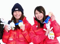 ミラノ・コルティナ冬季五輪のスノーボード女子スロープスタイルの表彰式で、笑顔を見せる金メダルの深田茉莉（左）と銅メダルの村瀬心椛＝18日、イタリア・リビーニョ（共同）