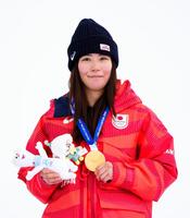 ミラノ・コルティナ冬季五輪スノーボード女子スロープスタイルで獲得した金メダルを手にする深田茉莉＝18日、イタリア・リビーニョ（共同）