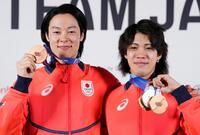 記者会見を終え、メダルを手にポーズをとるノルディックスキー・ジャンプ男子の小林陵侑（左）と二階堂蓮＝18日、イタリア・ミラノ（共同）