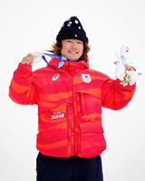 男子スロープスタイルで獲得した銀メダルを掲げる長谷川帝勝＝リビーニョ（共同）