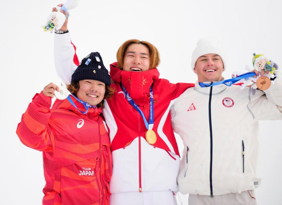 男子スロープスタイルで銀メダルを獲得し、表彰式で笑顔の長谷川帝勝（左）。中央は優勝した蘇翊鳴＝リビーニョ（共同）