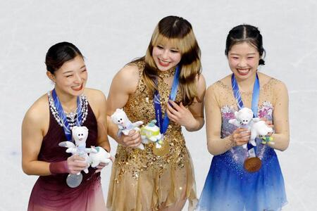 女子の表彰式で笑顔を見せる（左から）銀メダルの坂本花織、金メダルのアリサ・リュウ、銅メダルの中井亜美＝ミラノ（共同）
