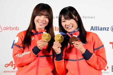　記者会見でメダルを掲げるスノーボード女子の深田茉莉（左）と村瀬心椛（共同）
