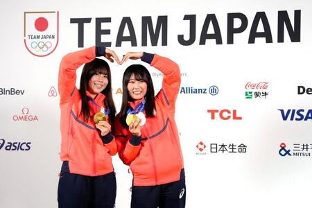 　記者会見でメダルを掲げるスノーボード女子の深田茉莉（左）と村瀬心椛（共同）