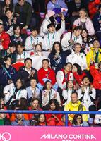 女子フリーで日の丸を手に応援する日本選手ら＝ミラノ（共同）