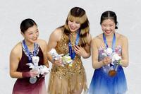 女子の表彰式で笑顔を見せる（左から）銀メダルの坂本花織、金メダルのアリサ・リュウ、銅メダルの中井亜美＝ミラノ（共同）