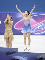 ミラノ・コルティナ五輪ジャンプして表彰台にあがる中井亜美＝ミラノアイススケートアリーナ（撮影・吉澤敬太）