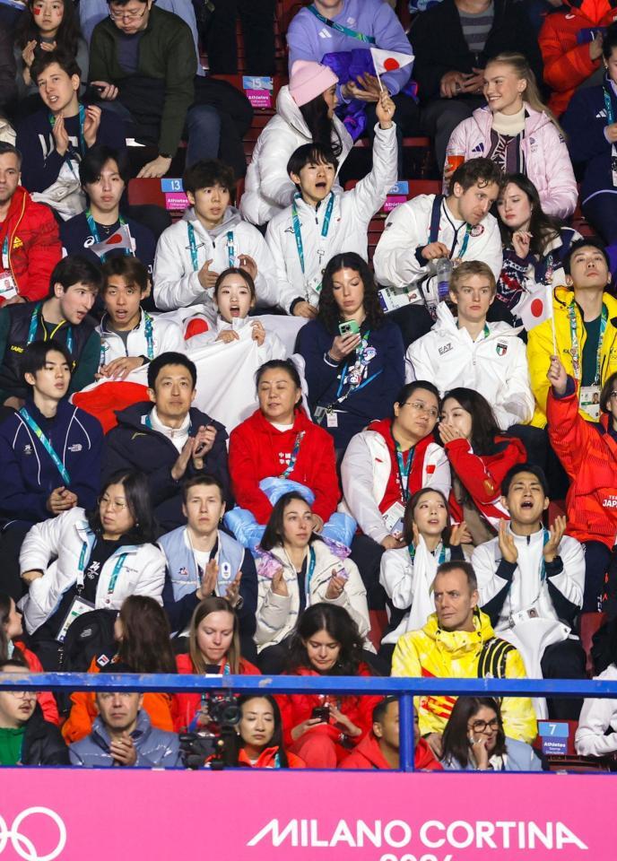 女子フリーで日の丸を手に応援する日本選手ら＝ミラノ（共同）