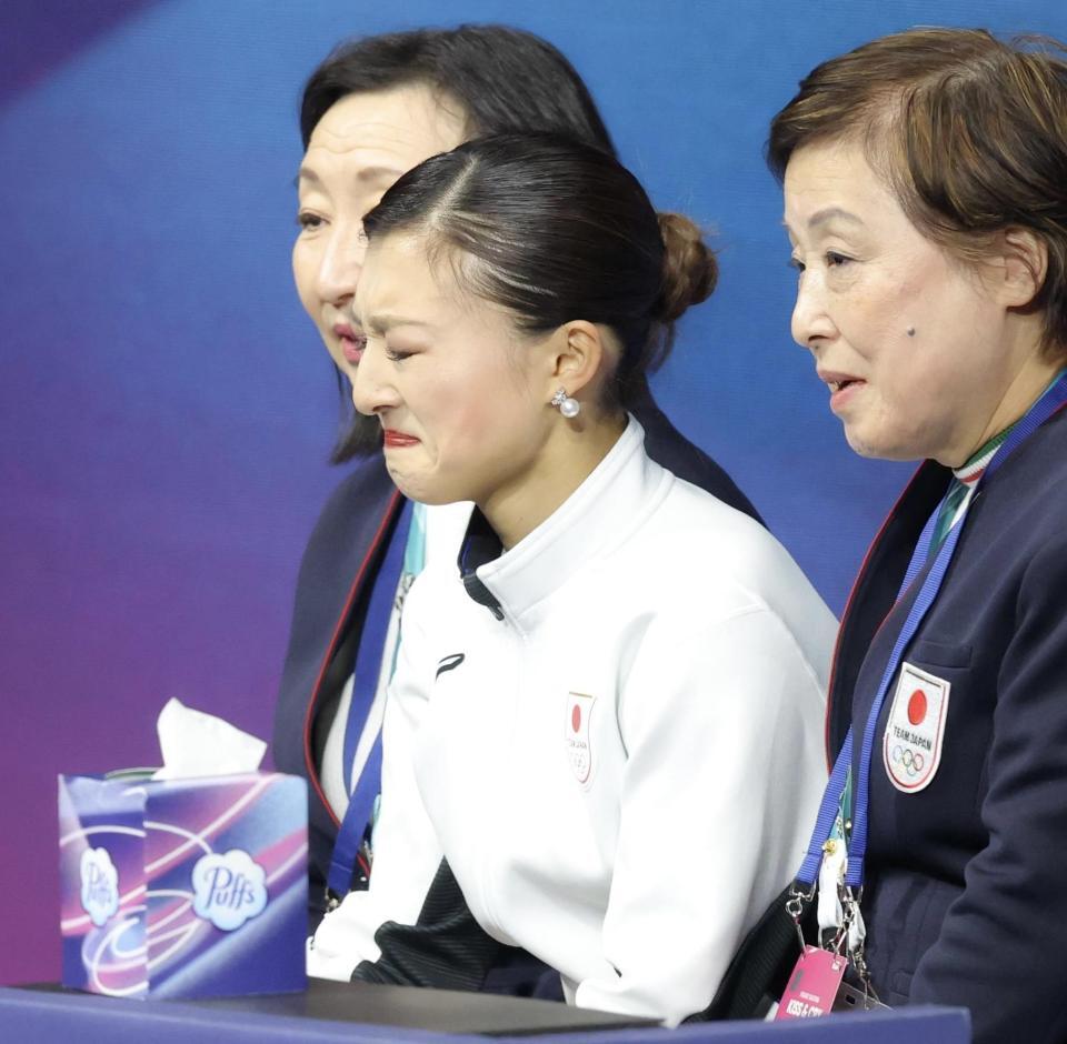 ミラノ・コルティナ五輪　キスアンドクライで号泣する坂本花織（中央）。右は中野コーチ＝ミラノアイススケートアリーナ（撮影・吉澤敬太）