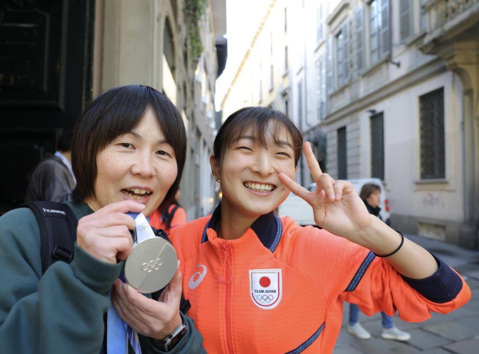 　中学時代の恩師の関口先生（左）に銀メダルを手渡し、笑顔を見せる坂本花織（撮影・吉澤敬太）