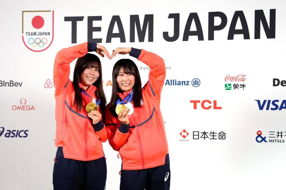 　記者会見でメダルを掲げるスノーボード女子の深田茉莉（左）と村瀬心椛（共同）