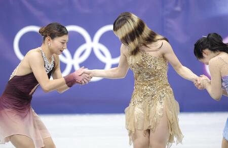 ミラノ・コルティナ五輪　金メダルのアリサ・リュウ（中央）と固く握手する坂本花織（左）と中井亜美（右）＝ミラノアイススケートアリーナ（撮影・吉澤敬太）