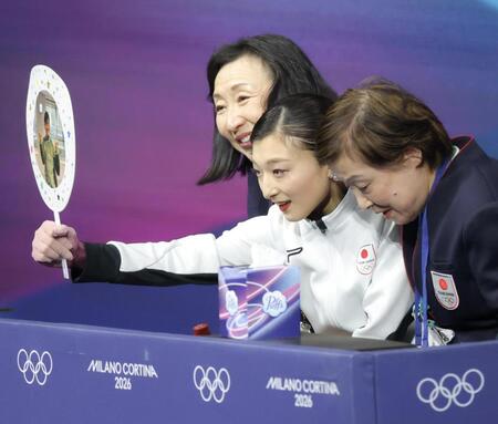 ミラノ・コルティナ五輪　キスアンドクライでうちわを差し出す坂本花織＝ミラノアイススケートアリーナ（撮影・吉澤敬太）