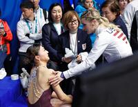 女子の順位が確定し、アンバー・グレン（手前右）に声をかけられる坂本花織＝ミラノ（共同）