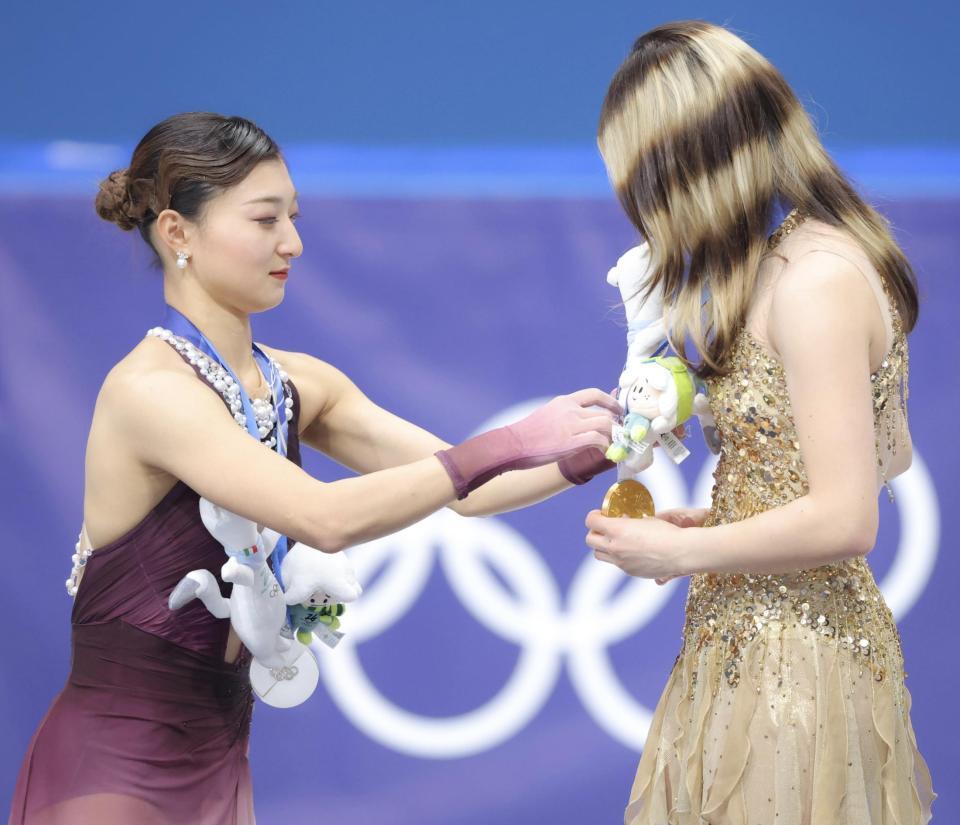 ミラノ・コルティナ五輪アリサ・リュウ（右）の金メダルにマスコットをかけてあげる坂本花織＝ミラノアイススケートアリーナ（撮影・吉澤敬太）