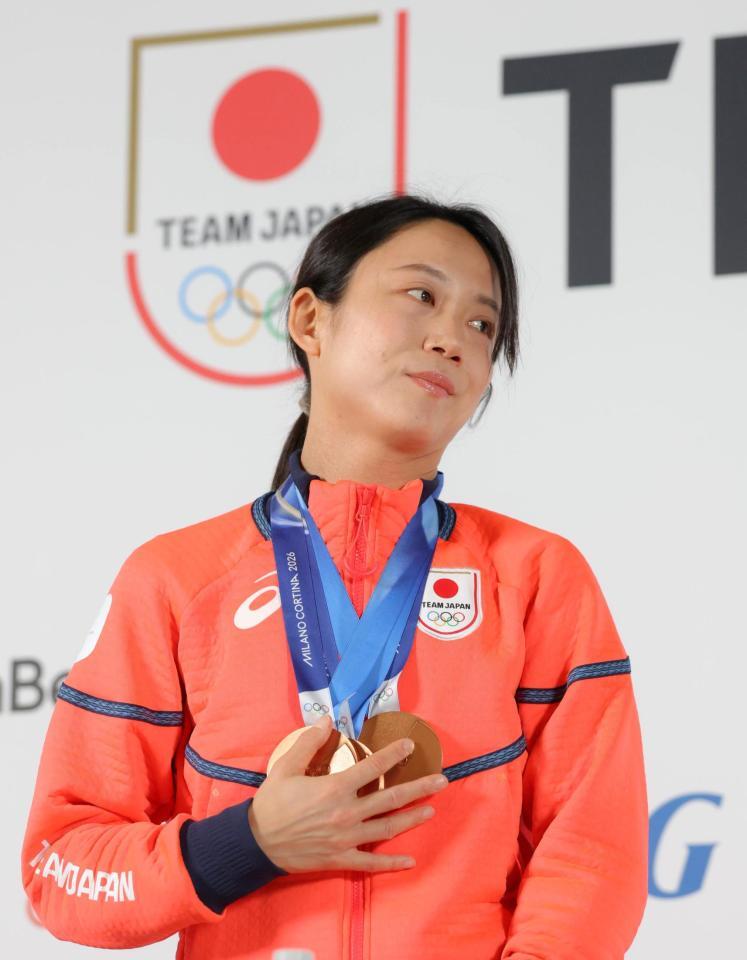メダルを手で押さえる高木美帆＝ミラノのジャパンハウス（撮影・吉澤敬太）