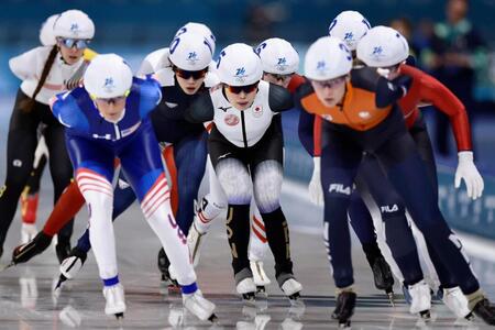 滑走する佐藤綾乃（中央）＝共同