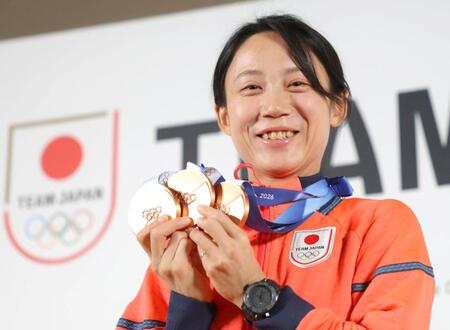 笑顔でメダルを掲げる高木美帆＝ミラノのジャパンハウス（撮影・吉澤敬太）