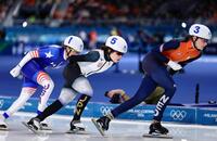 滑走する佐藤綾乃（中央）＝共同