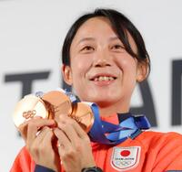 笑顔でメダルを掲げる高木美帆＝ミラノのジャパンハウス（撮影・吉澤敬太）