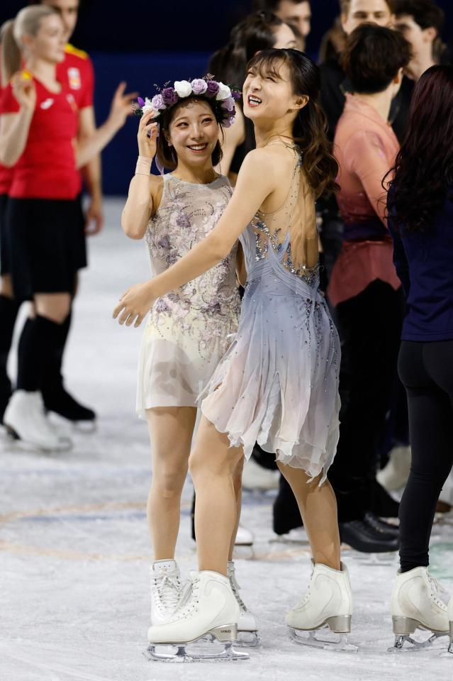 三浦璃来（左）に花の冠をのせて笑顔の坂本花織＝ミラノ（共同）