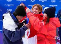 深田茉莉（右）から金メダルをかけてもらう佐藤康弘コーチ。中央は練習仲間で五輪王者の蘇翊鳴（共同）