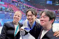 銀メダルを手に、父の正和コーチ（右）、カロリナ・コストナー・コーチ（左）と喜ぶ鍵山優真＝１３日