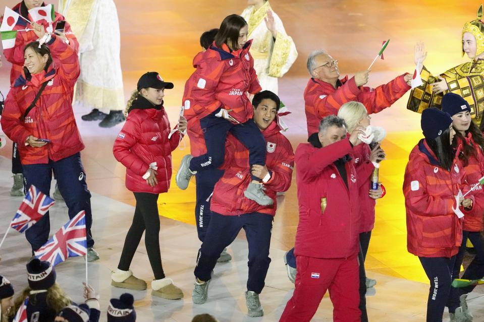 　閉会式でフィギュアスケートの三浦璃来（中央上）を持ち上げて入場する木原龍一＝22日、イタリア・ベローナ（共同）
