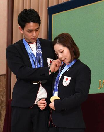 金メダルをかけ直す三浦璃来（右）とそれを手伝う木原龍一（撮影・佐藤厚）