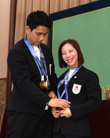 金メダルをかけ直す三浦璃来（右）とそれを手伝う木原龍一（撮影・佐藤厚）