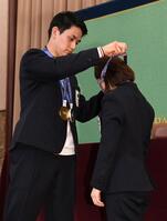 金メダルをかけ直す三浦璃来（右）とそれを手伝う木原龍一（撮影・佐藤厚）