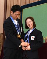 金メダルをかけ直す三浦璃来（右）とそれを手伝う木原龍一（撮影・佐藤厚）