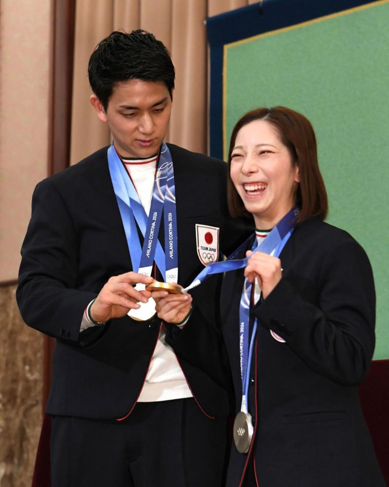 金メダルをかけ直す三浦璃来（右）とそれを手伝う木原龍一（撮影・佐藤厚）