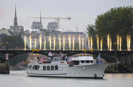 　パリ五輪の開会式で、セーヌ川を航行する韓国などの選手団を乗せた船（共同）