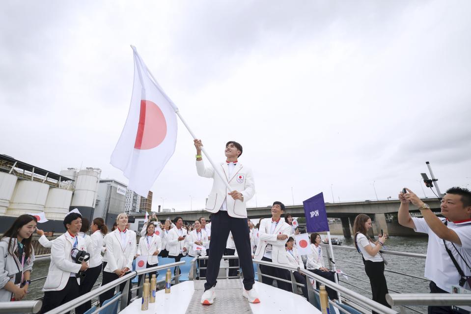 　セーヌ川で行われたパリ五輪の開会式で、日の丸を手にする日本選手団旗手の半井重幸（中央）＝26日、パリ（ゲッティ＝共同）