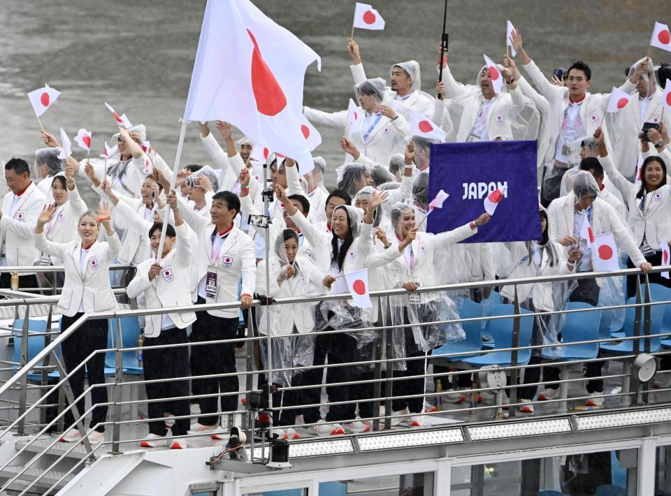 　パリ五輪の開会式で、セーヌ川を船でパレードする日本選手団。（手前左から）旗手の江村美咲、半井重幸＝26日、パリ（共同）