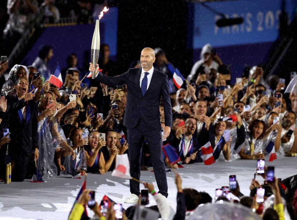 　パリ五輪の開会式で聖火を掲げるサッカー元フランス代表のジダンさん（ロイター＝共同）