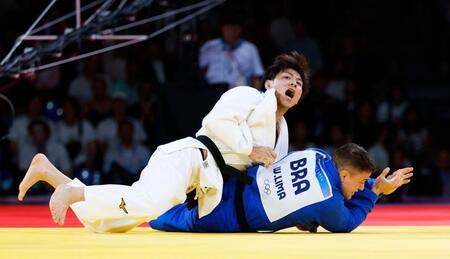 　男子66キロ級決勝でブラジル選手（下）から技ありを奪う阿部一二三。金メダルを獲得した（共同）