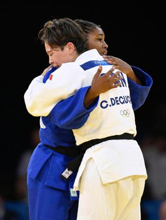 　女子５７キロ級準決勝でフランス選手（奥）を破り、健闘をたたえ合うカナダの出口クリスタ（共同）