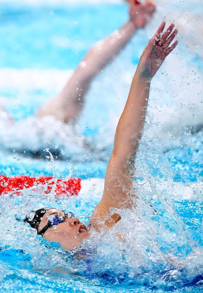 　背泳ぎで力泳する第１泳者の白井璃緒（共同）